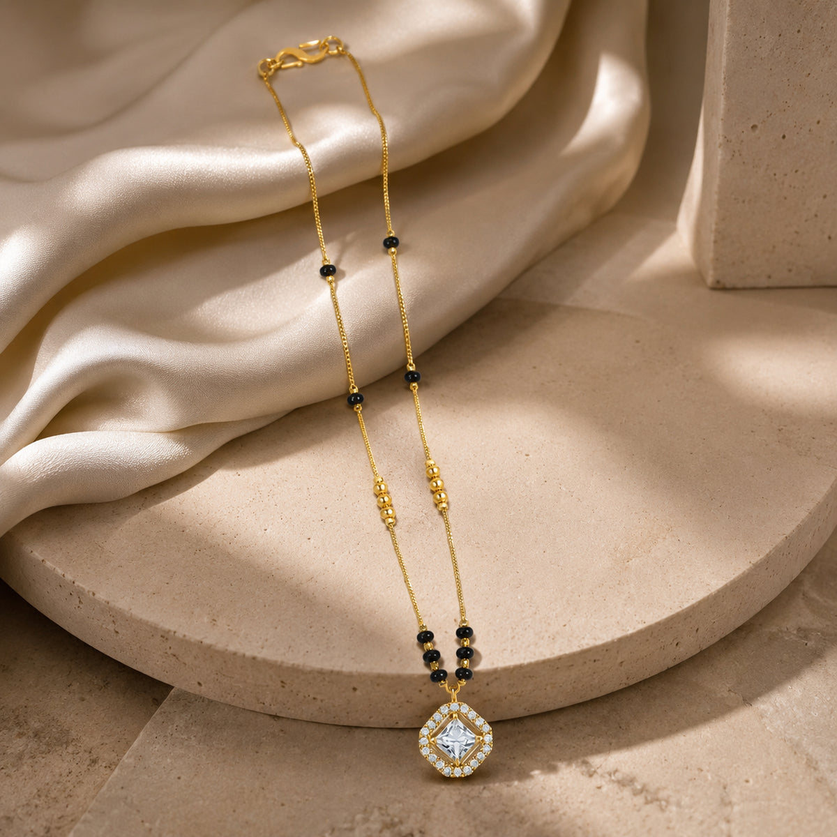 Square-pendant mangalsutra draped over a cream display block