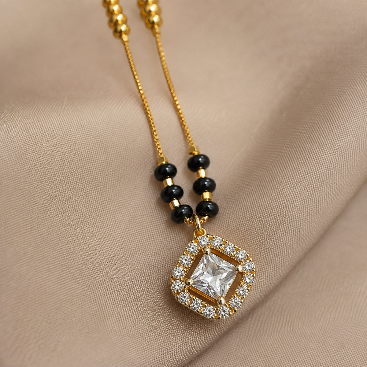 Close-up of the square clear-stone pendant and black bead clusters