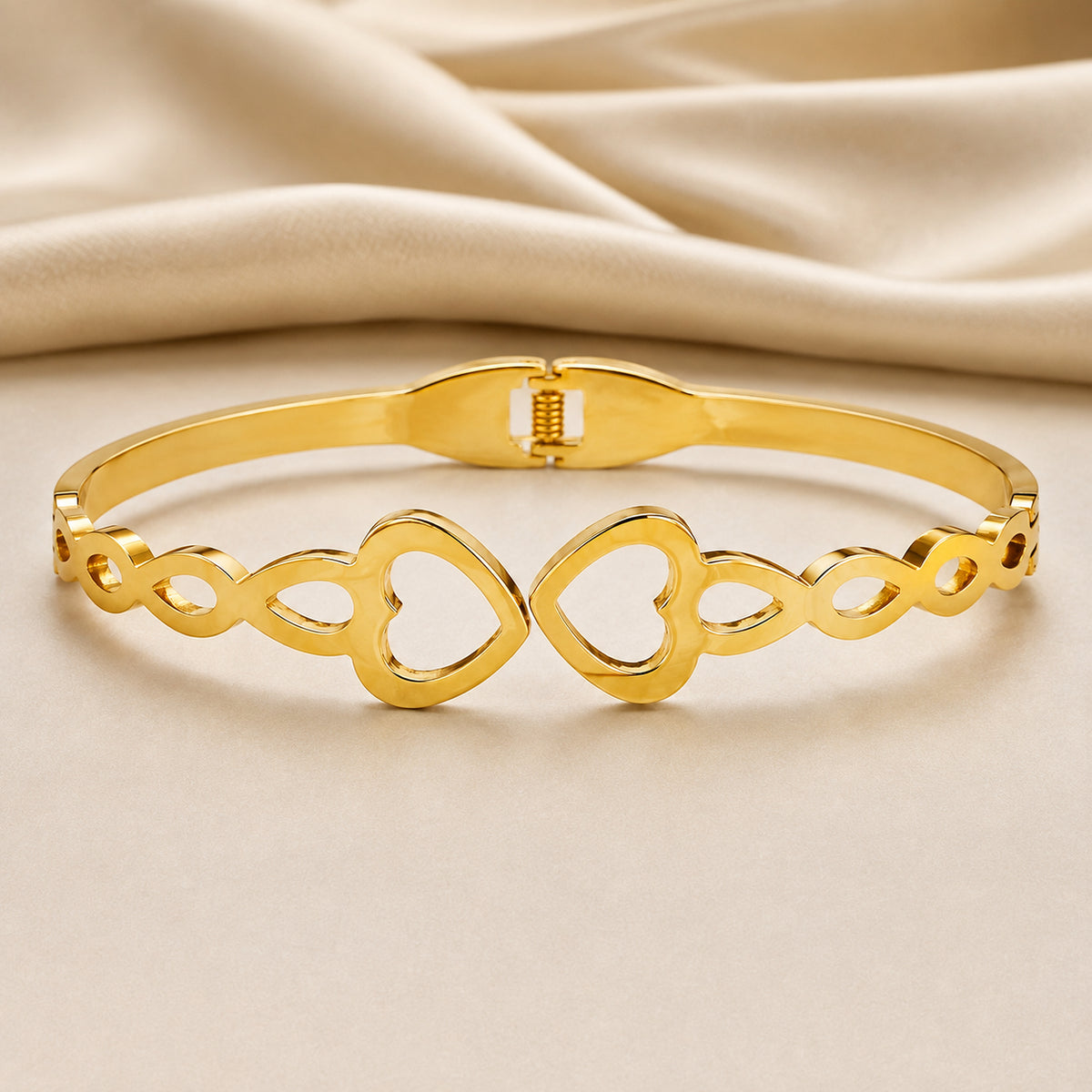 Double-heart openwork bangle on pale fabric with satin behind