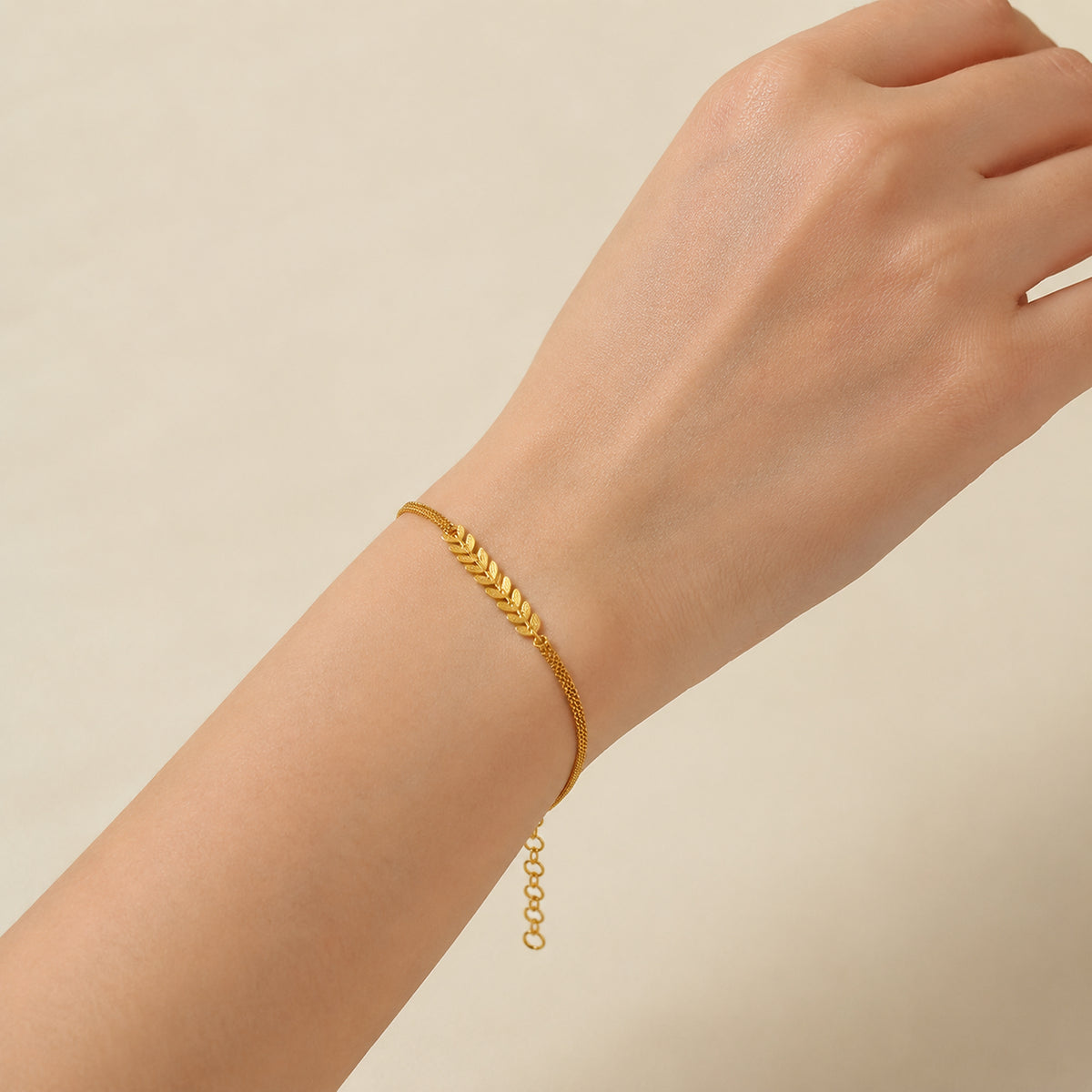 Leaf motif bracelet shown on a wrist for scale