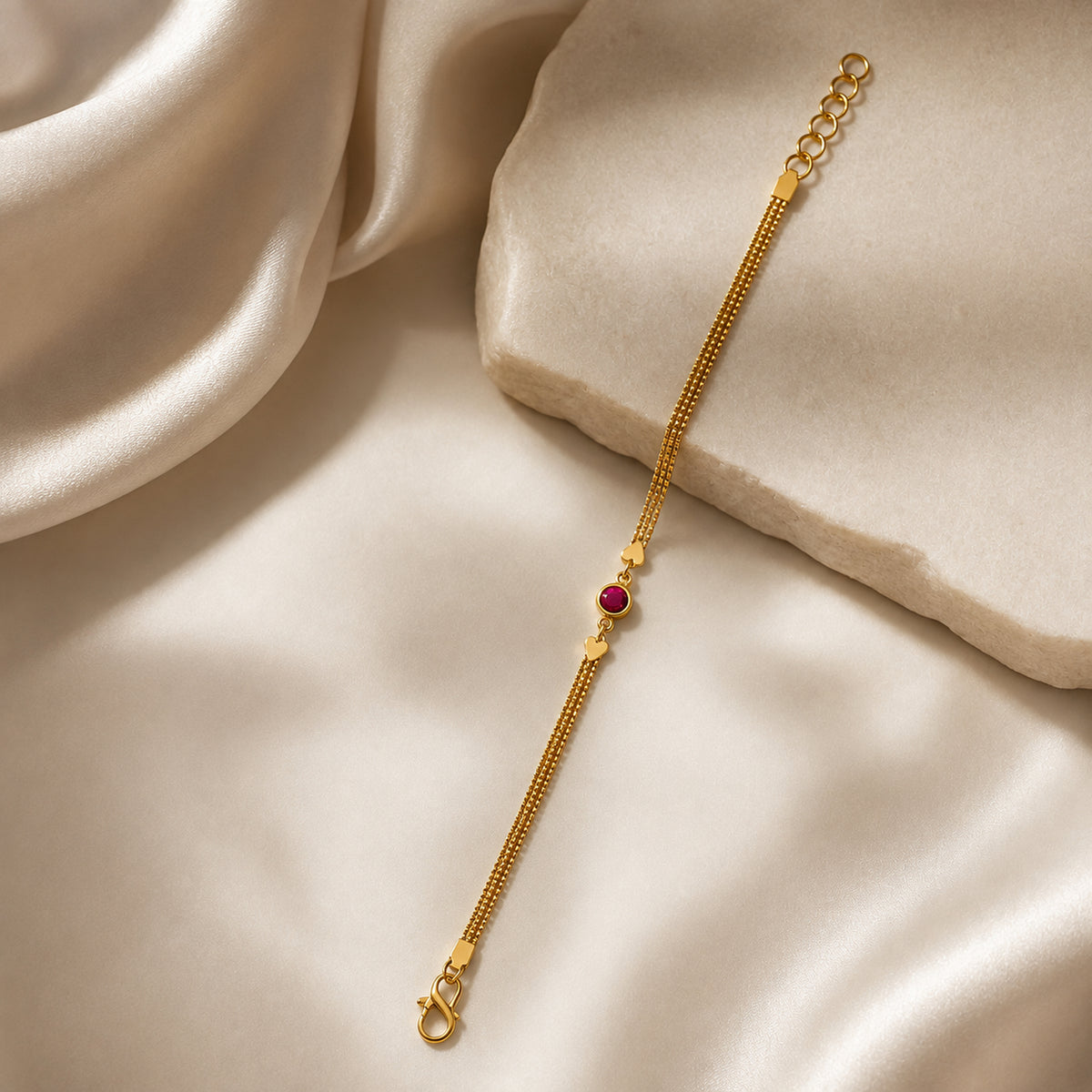 Heart accent chain bracelet displayed beside a pale stone block
