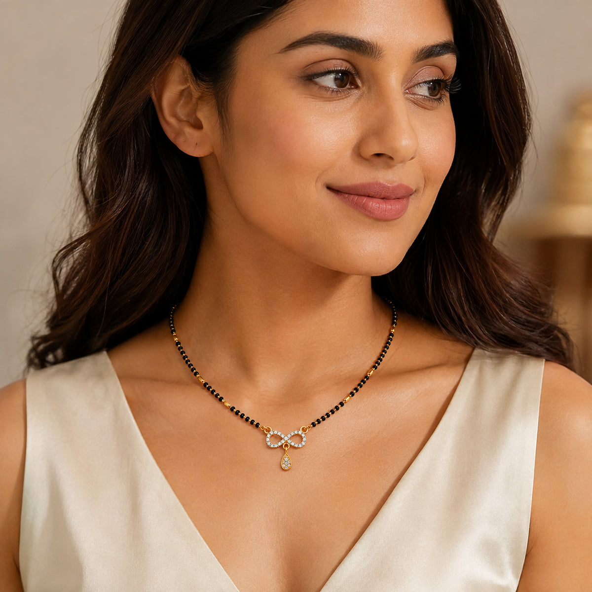 Woman wearing the infinity pendant mangalsutra with teardrop drop