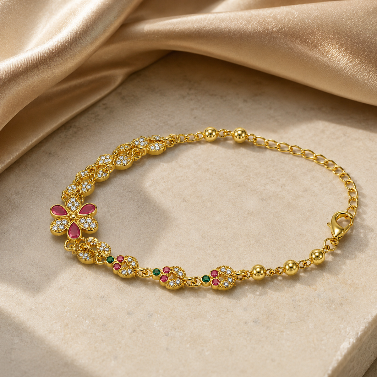 Gold-tone multicolour floral bracelet arranged on a pale stone slab