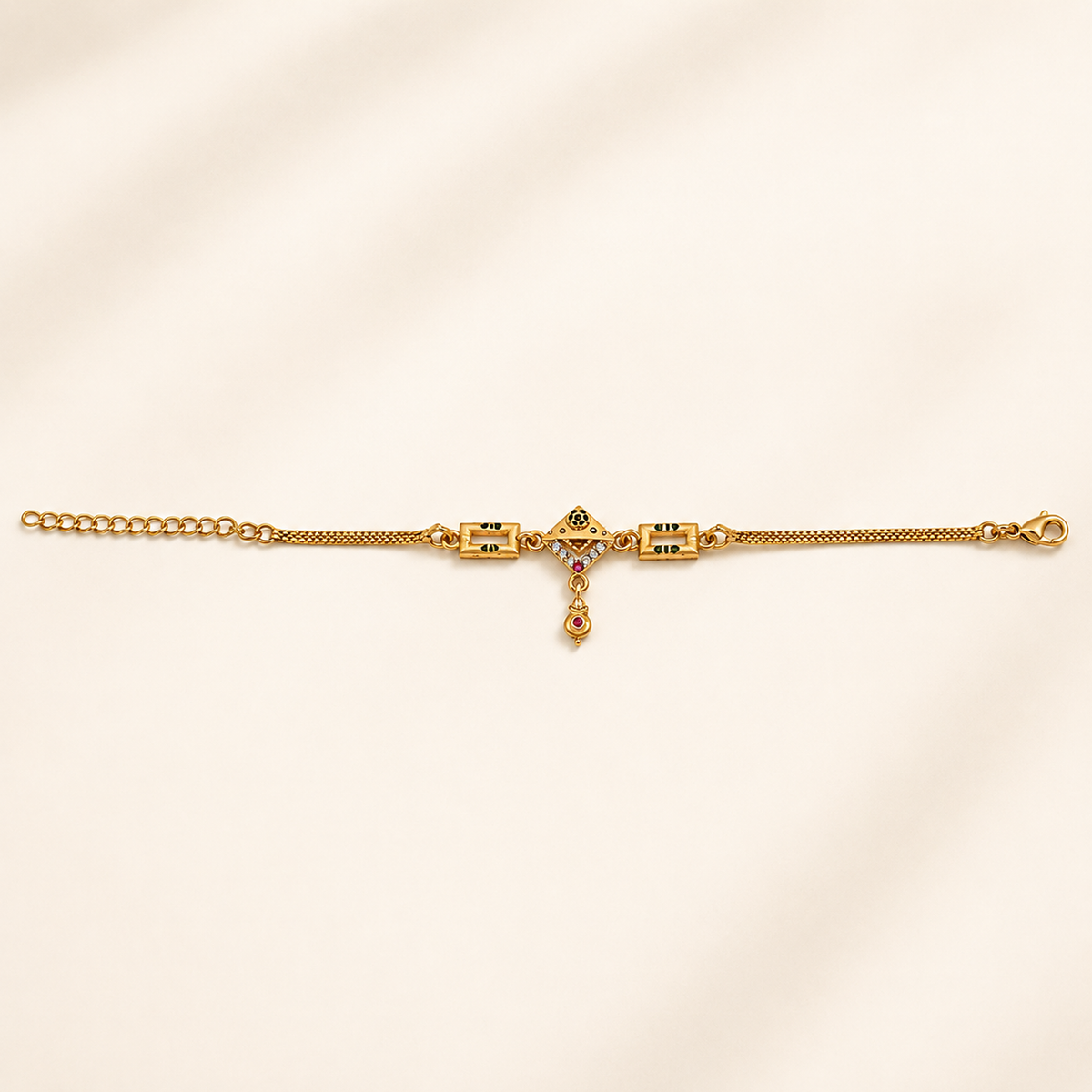 Geometric drop charm bracelet laid flat against a pale background