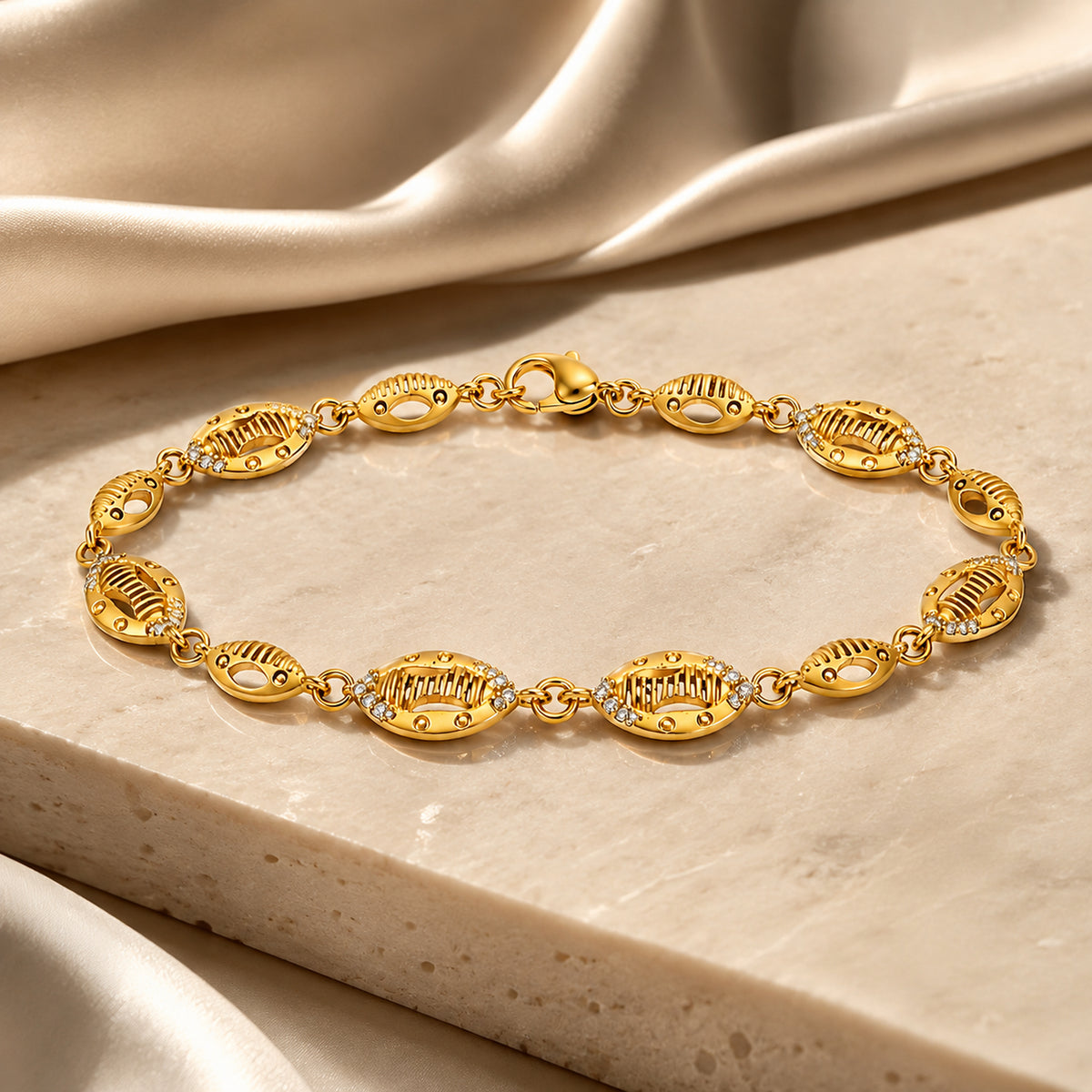 Gold-tone oval link bracelet displayed on a pale stone slab