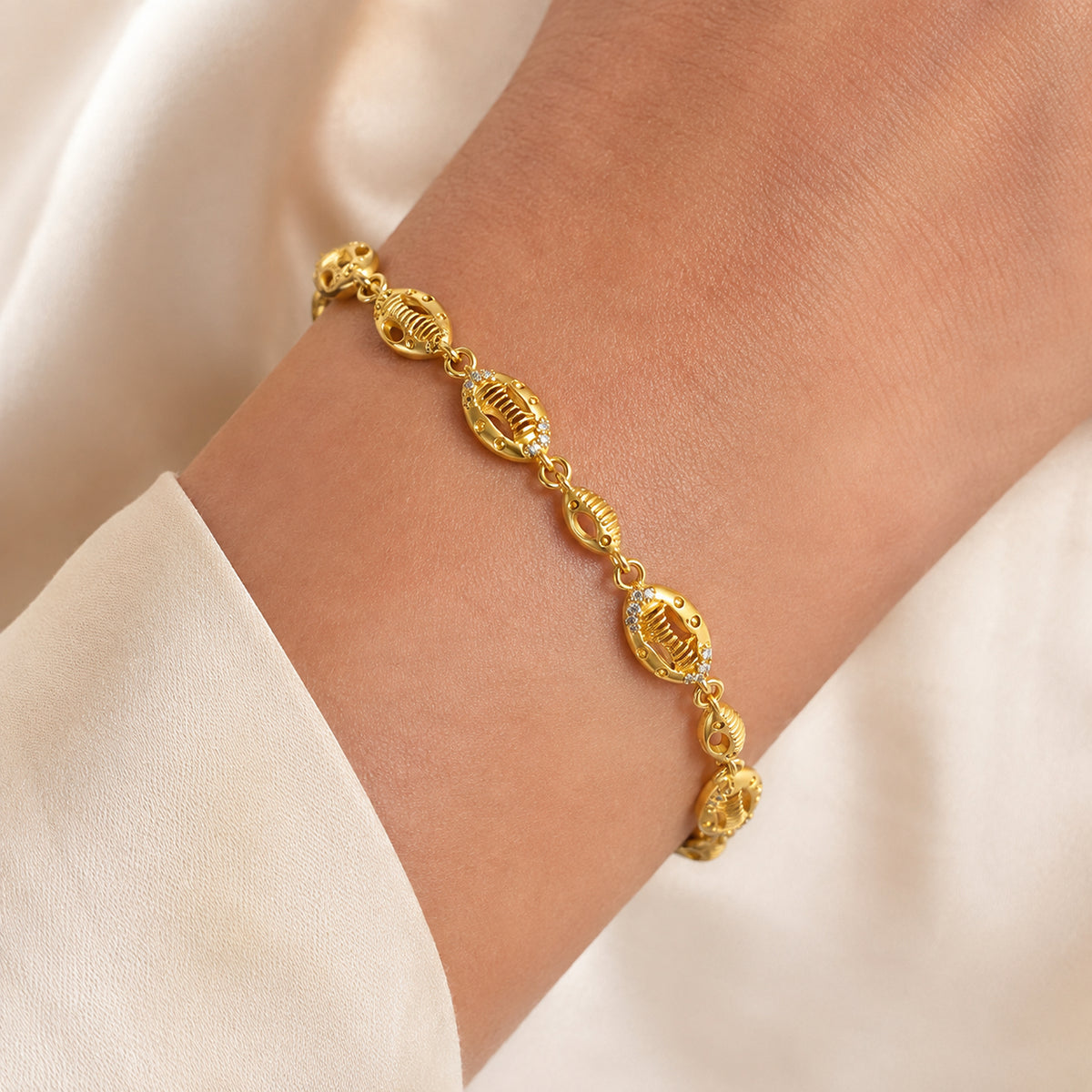 Textured oval links and clear stone accents shown around a wrist