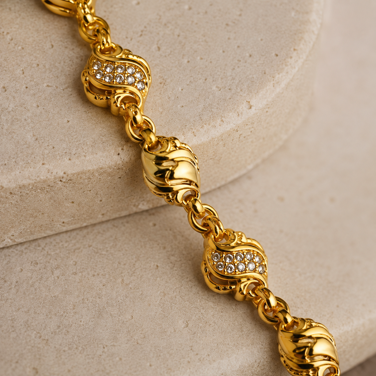 Close-up of clear stone wave links and sculpted gold-tone beads