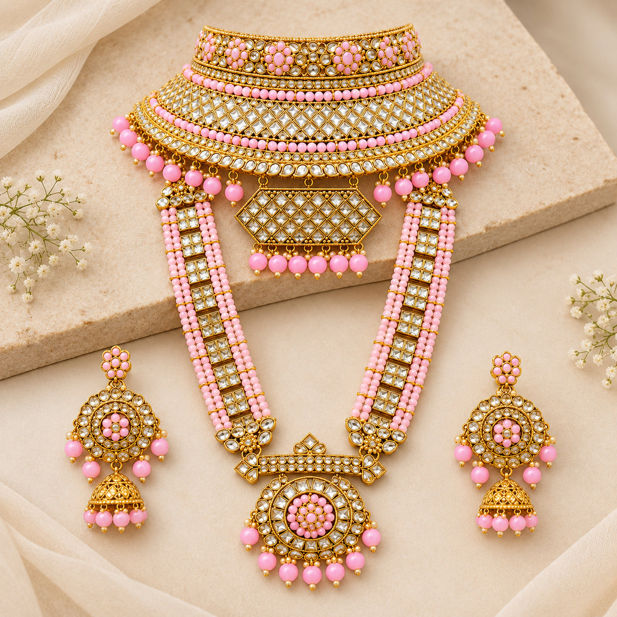 Pink lattice choker, round-pendant haar and jhumkas laid flat on pale fabric