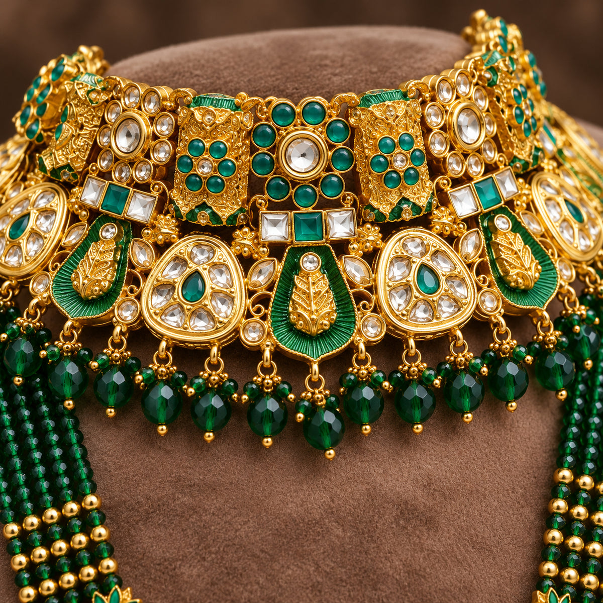 Close-up of green accents, white stones and bead drops on the bridal choker