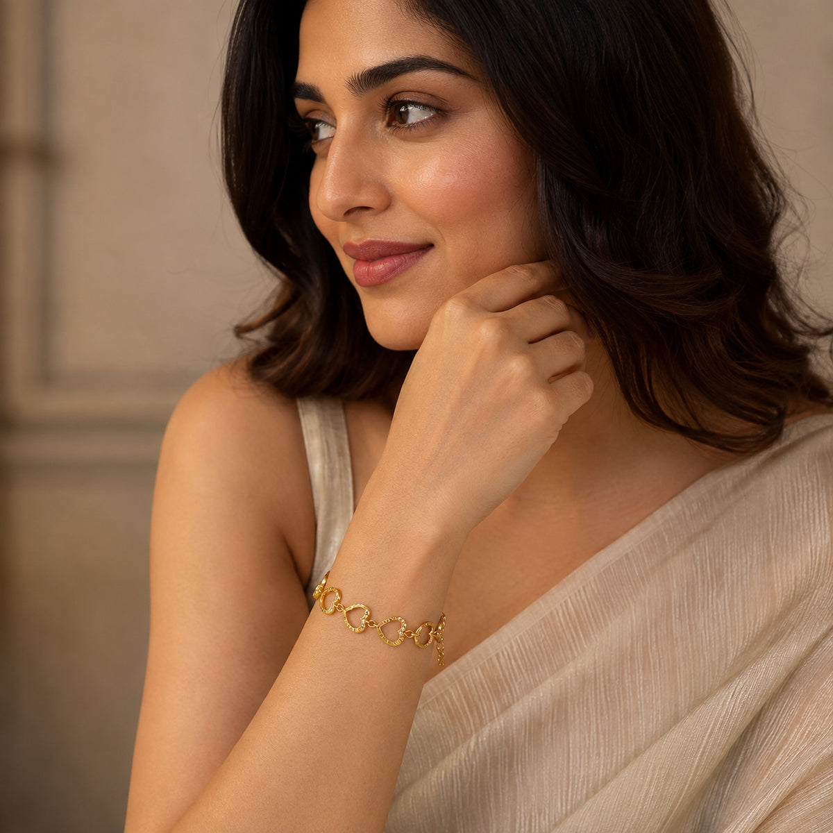 Open-heart link bracelet worn with a cream saree