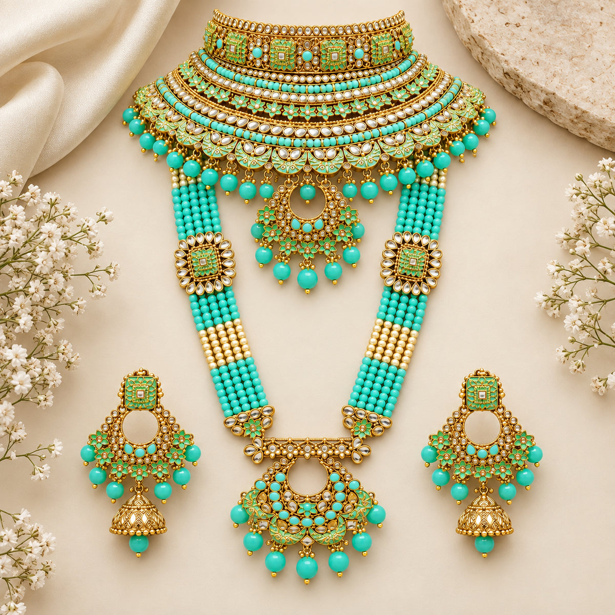 Mint turquoise choker, multi-strand haar and earrings arranged on cream fabric