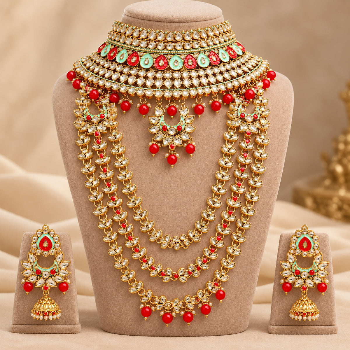 Red and mint green Kundan-style bridal set on a beige bust with matching earrings