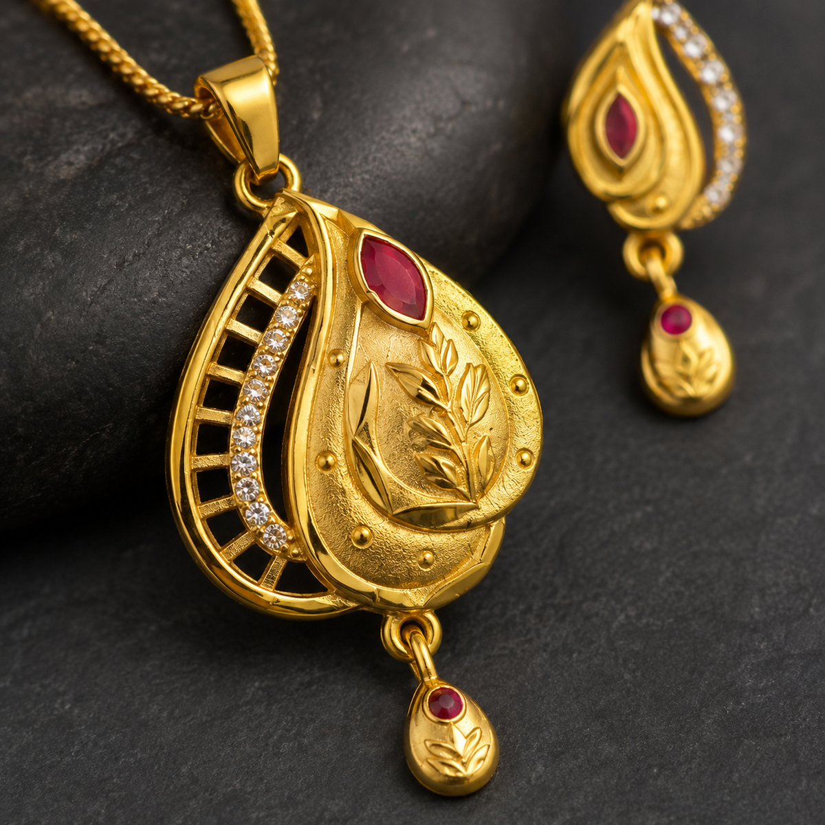 Close-up of the engraved leaf, red accent and clear-stone openwork pendant