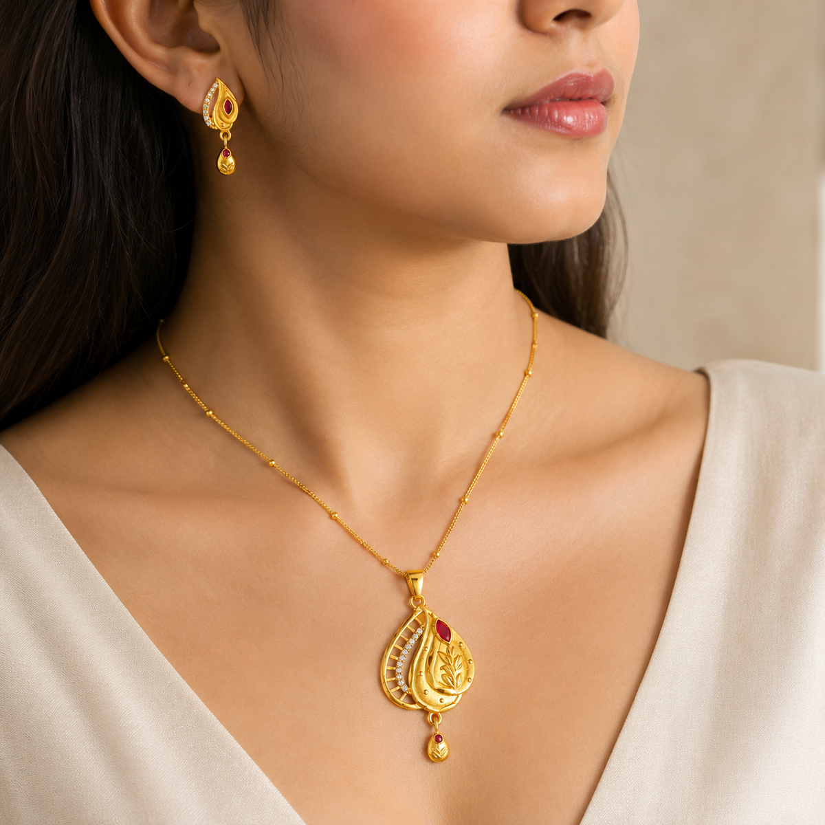 Close view of the red leaf pendant necklace and matching earring being worn