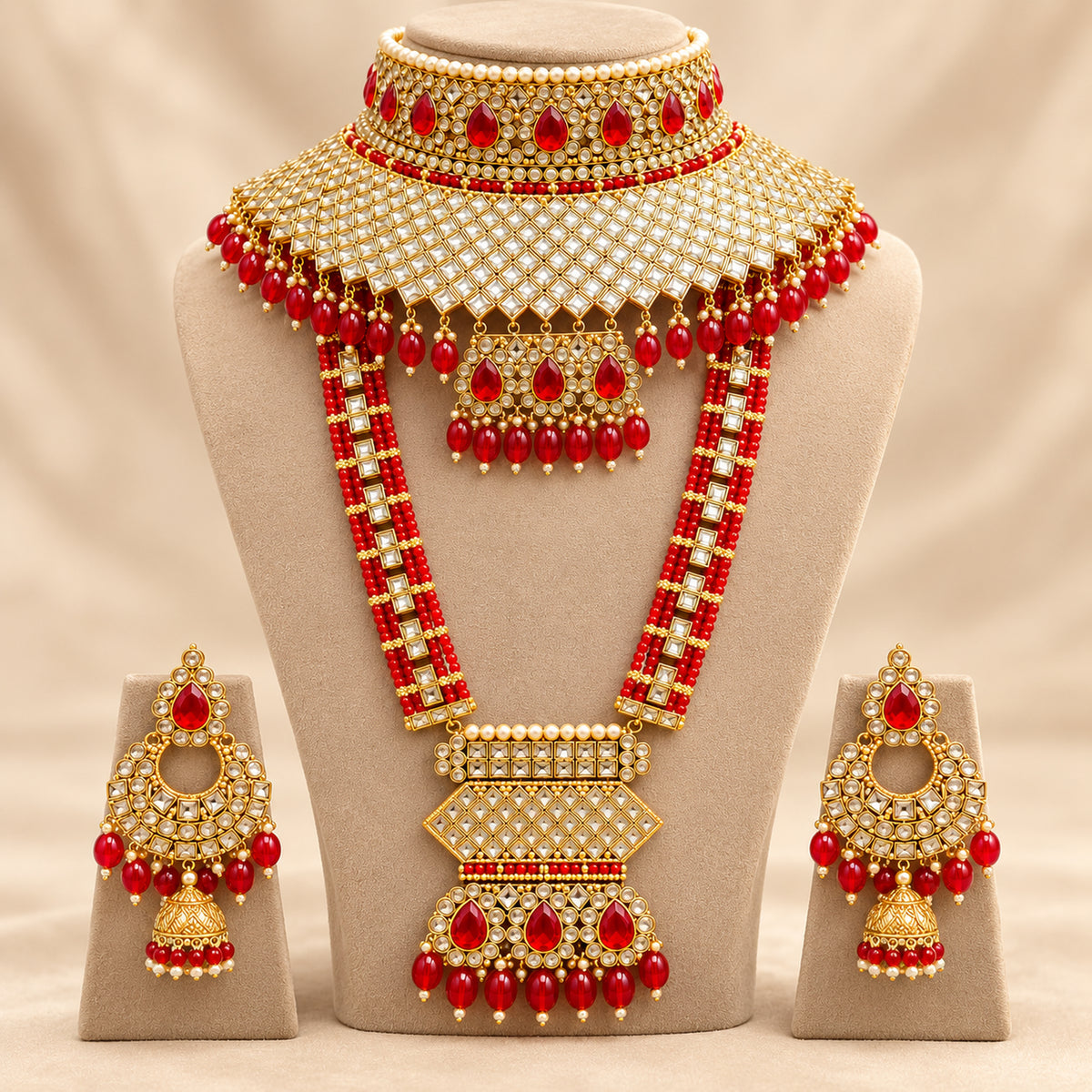 Red teardrop lattice bridal set arranged on a beige bust with matching earrings