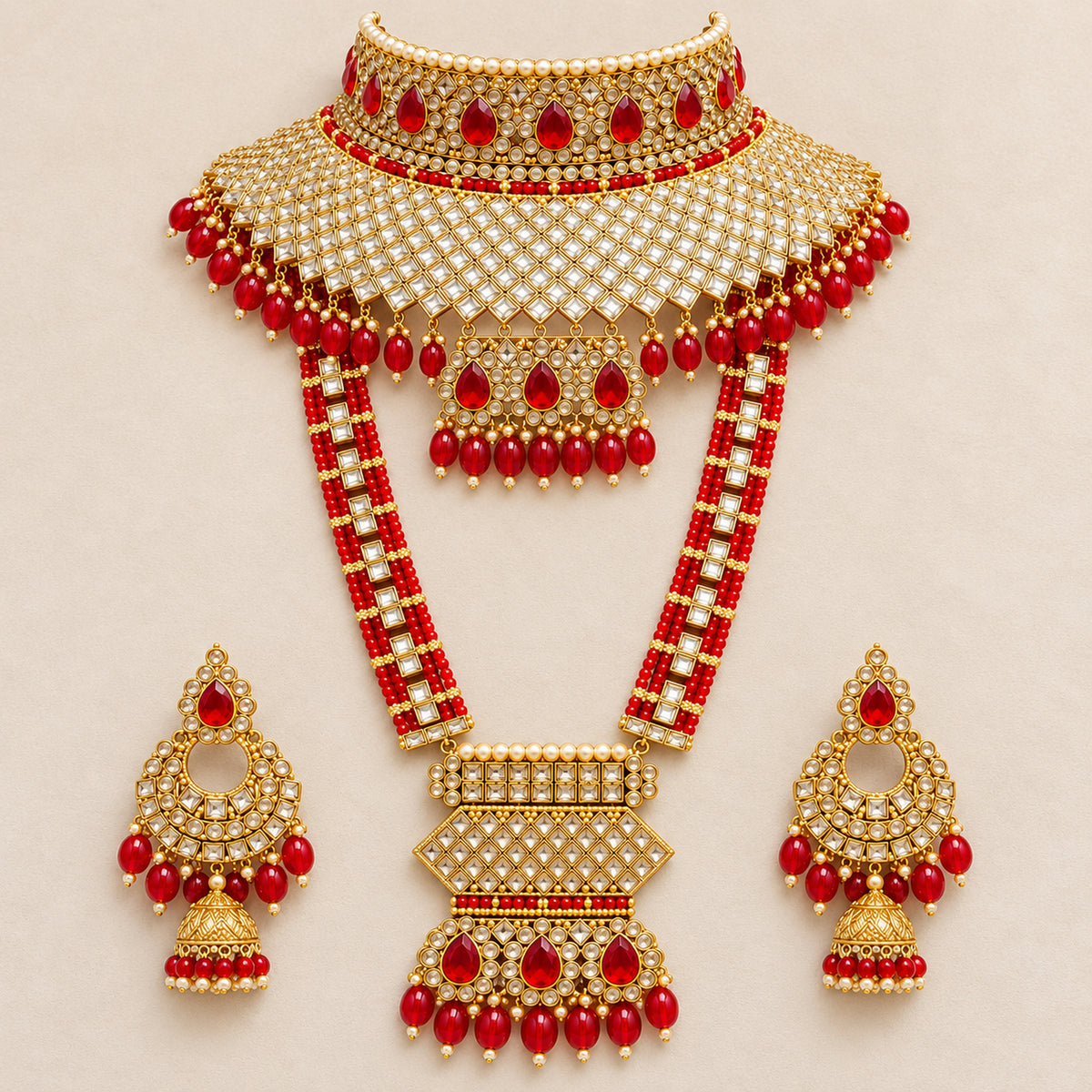 Red lattice choker, geometric-pendant haar and jhumka earrings arranged on pale fabric