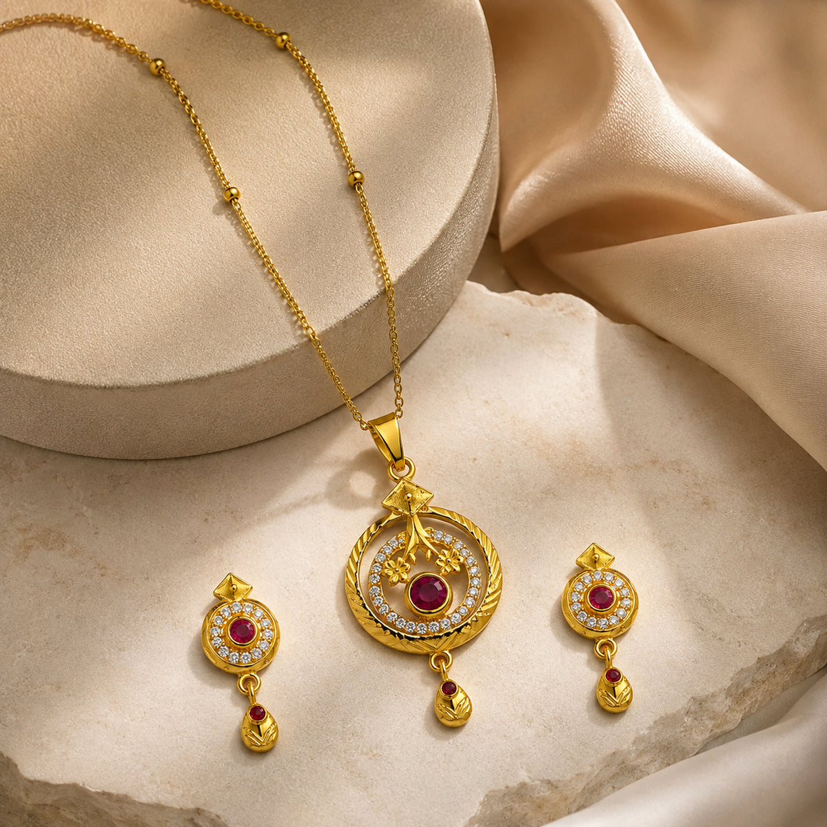 Round red pendant necklace and earrings beside cream display blocks