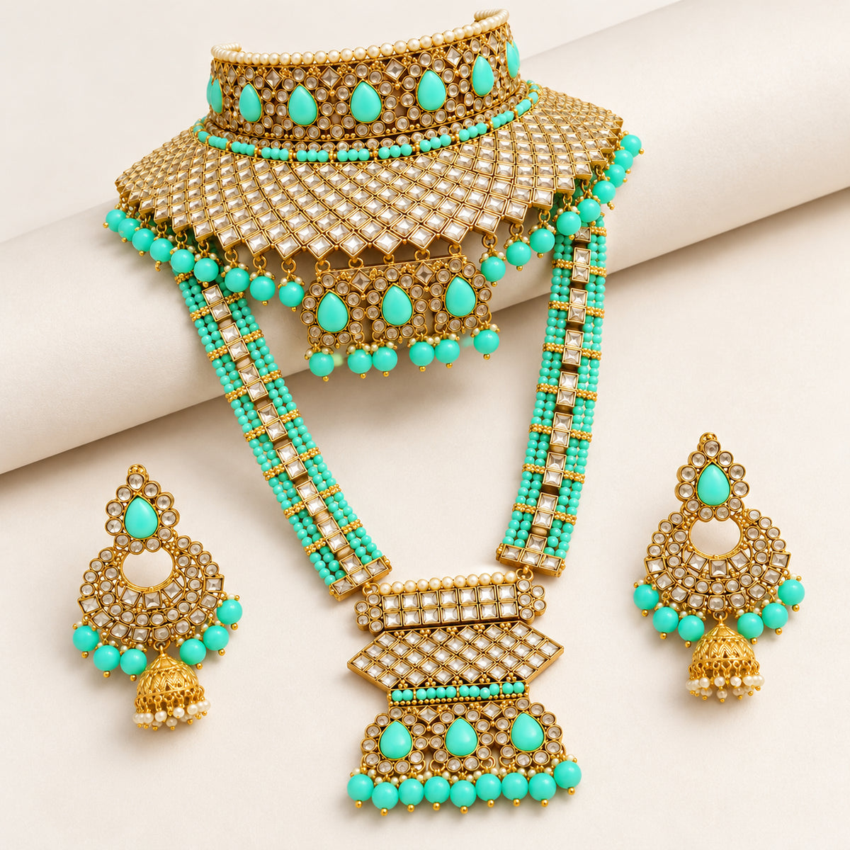 Turquoise choker, geometric-pendant long haar and earrings arranged on pale fabric